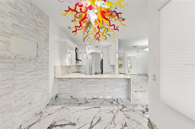 2238 Shirecrest Cove Way, Lutz, FL 33558 - kitchen featuring wall chimney exhaust hood, arched walkways, white cabinets, marble tiled floors, and refrigerator