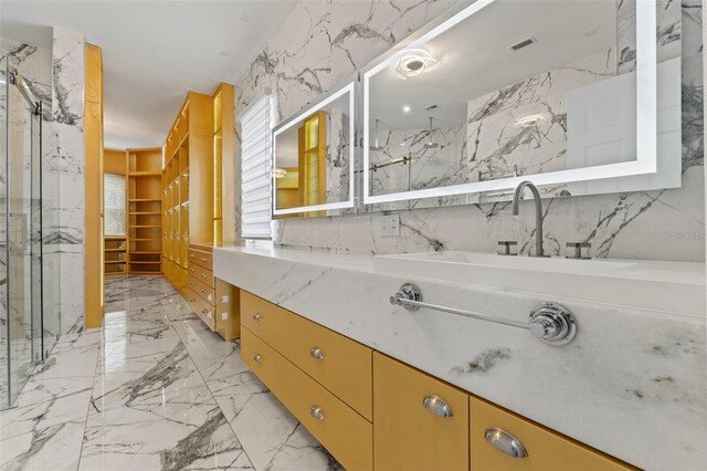 2238 Shirecrest Cove Way, Lutz, FL 33558 - bathroom with stone wall, a marble finish shower, marble tiled floors, and vanity