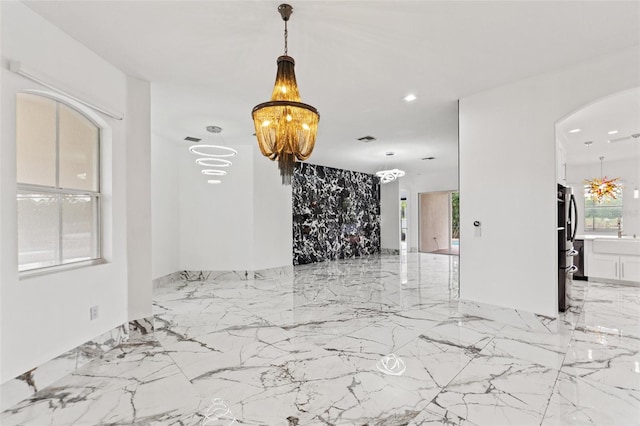 2238 Shirecrest Cove Way, Lutz, FL 33558 - unfurnished room with a chandelier, arched walkways, light marble finish flooring, and recessed lighting