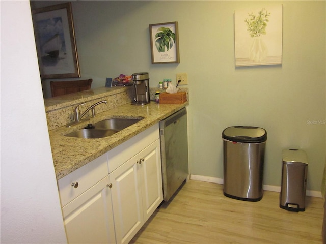 2616 Cove Cay Dr Unit 104, Clearwater, FL 33760 - kitchen featuring stainless steel dishwasher, a sink, baseboards, light wood finished floors, and light stone countertops