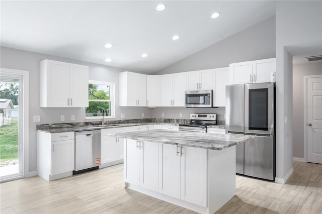 5319 Lantana St, Zephyrhills, FL 33542 - kitchen with stainless steel appliances, light stone countertops, a sink, white cabinets, and vaulted ceiling