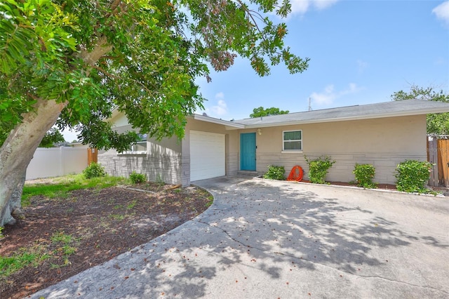 12372 113th St, Largo, FL 33778 - ranch-style house featuring an attached garage, driveway, stucco siding, and stone siding