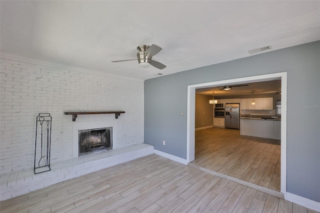 12372 113th St, Largo, FL 33778 - unfurnished living room with ceiling fan, wood finished floors, a brick fireplace, and baseboards