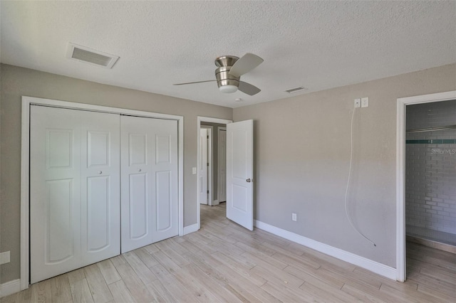 12372 113th St, Largo, FL 33778 - unfurnished bedroom featuring a closet, light wood finished floors, baseboards, and a textured ceiling