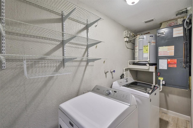 12372 113th St, Largo, FL 33778 - laundry room with separate washer and dryer, wood finished floors, water heater, baseboards, and a textured ceiling