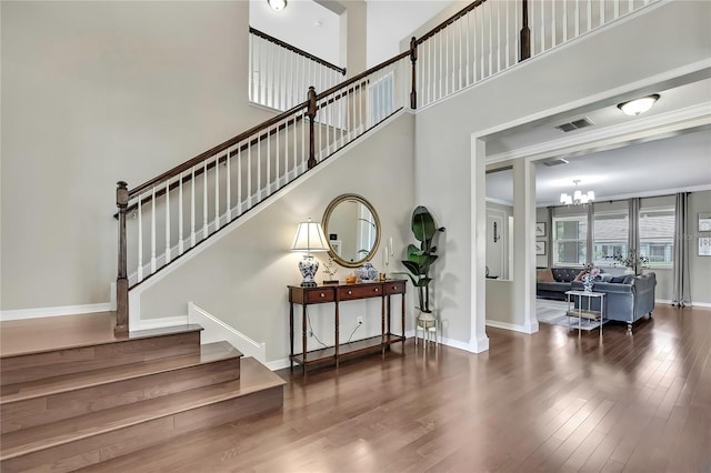 1821 Cherry Walk Rd, Lutz, FL 33558 - stairway featuring wood finished floors, a chandelier, baseboards, and a towering ceiling