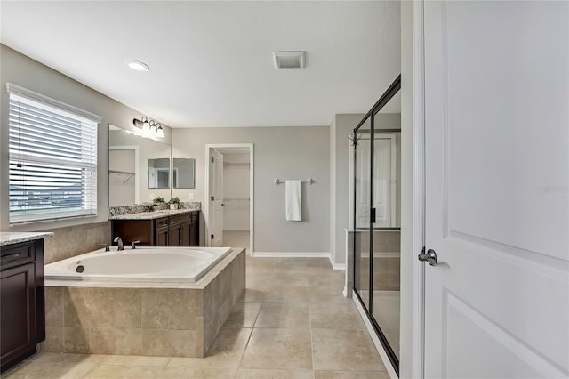 1821 Cherry Walk Rd, Lutz, FL 33558 - full bath with vanity, a walk in closet, a shower stall, a garden tub, and tile patterned floors