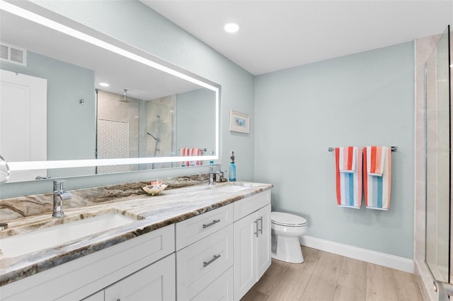12525 3rd St E Unit 303, Treasure Island, FL 33706 - full bathroom with a shower stall, wood finished floors, double vanity, toilet, and recessed lighting