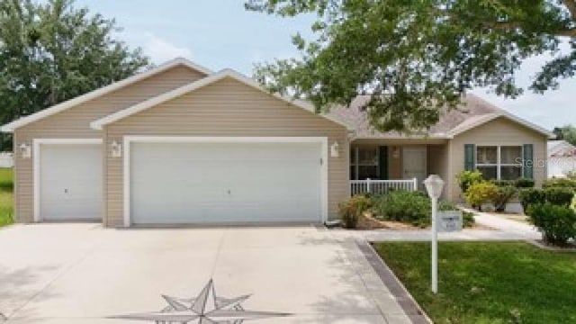 310 Knoll Pl, The Villages, FL 32162 - single story home featuring an attached garage, concrete driveway, and a porch