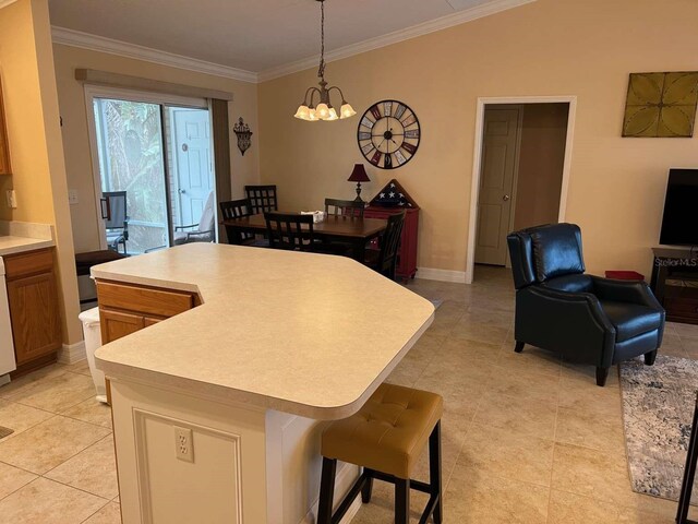 310 Knoll Pl, The Villages, FL 32162 - kitchen with light countertops, light tile patterned floors, hanging light fixtures, ornamental molding, and open floor plan