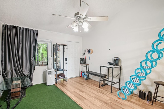 20921 Haulover Cv Unit 8, Lutz, FL 33558 - workout room featuring a textured ceiling, wood finished floors, and a ceiling fan