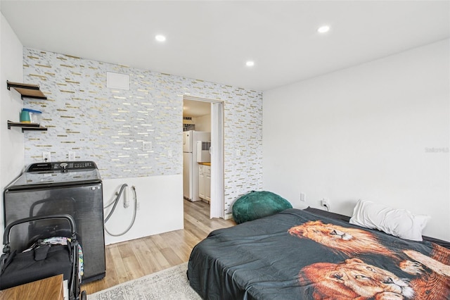 20921 Haulover Cv Unit 8, Lutz, FL 33558 - bedroom featuring washer / dryer, light wood finished floors, freestanding refrigerator, recessed lighting, and an accent wall
