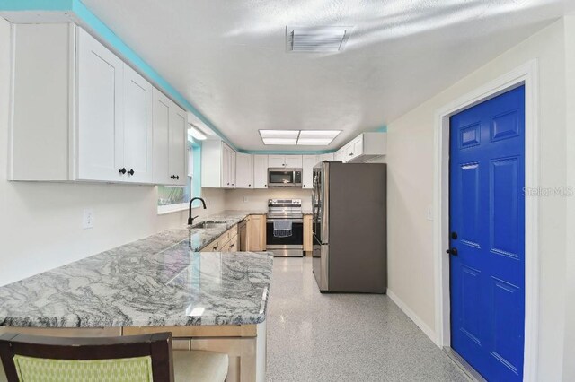 13323 Susan Dr, Hudson, FL 34667 - kitchen featuring stainless steel appliances, a sink, dark aggregate flooring, light stone countertops, and baseboards