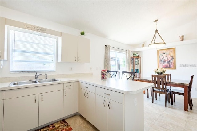 1602 Taylor Lake Cir, Largo, FL 33778 - kitchen with a peninsula, light countertops, decorative light fixtures, light tile patterned floors, and lofted ceiling