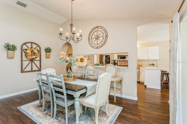 8549 Pinafore Dr, New Port Richey, FL 34653 - dining room featuring vaulted ceiling, dark wood-style floors, a chandelier, arched walkways, and baseboards
