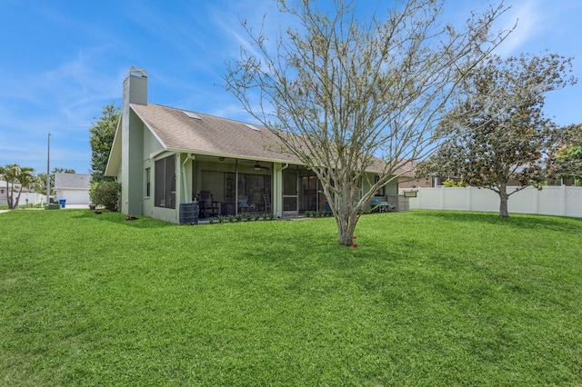 8549 Pinafore Dr, New Port Richey, FL 34653 - back of house with a sunroom, a chimney, ceiling fan, roof with shingles, and stucco siding