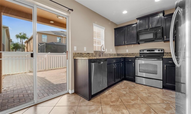 9752 Trumpet Vine Loop, Trinity, FL 34655 - kitchen featuring appliances with stainless steel finishes, light stone counters, dark cabinets, and recessed lighting
