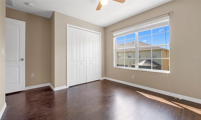 9752 Trumpet Vine Loop, Trinity, FL 34655 - unfurnished bedroom featuring baseboards, a closet, wood finished floors, and a ceiling fan