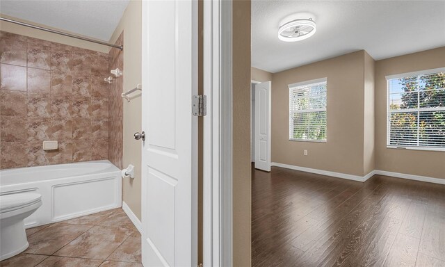 9752 Trumpet Vine Loop, Trinity, FL 34655 - full bath featuring toilet,  shower combination, wood finished floors, and baseboards