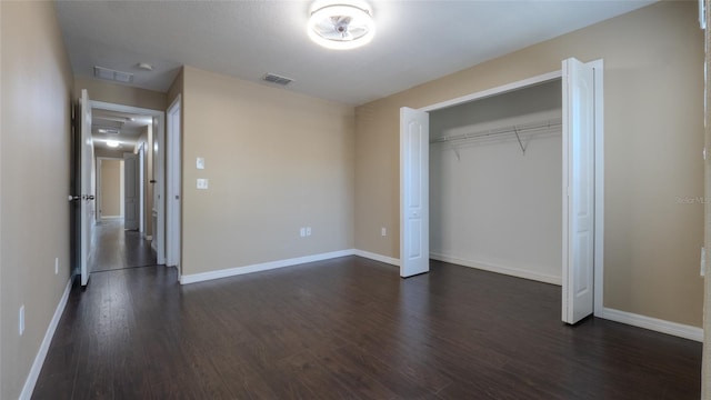 9752 Trumpet Vine Loop, Trinity, FL 34655 - unfurnished bedroom with dark wood finished floors, baseboards, and a closet