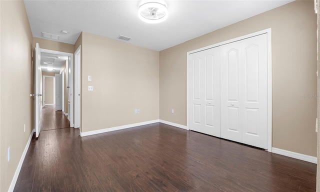 9752 Trumpet Vine Loop, Trinity, FL 34655 - unfurnished bedroom featuring dark wood finished floors, baseboards, and a closet