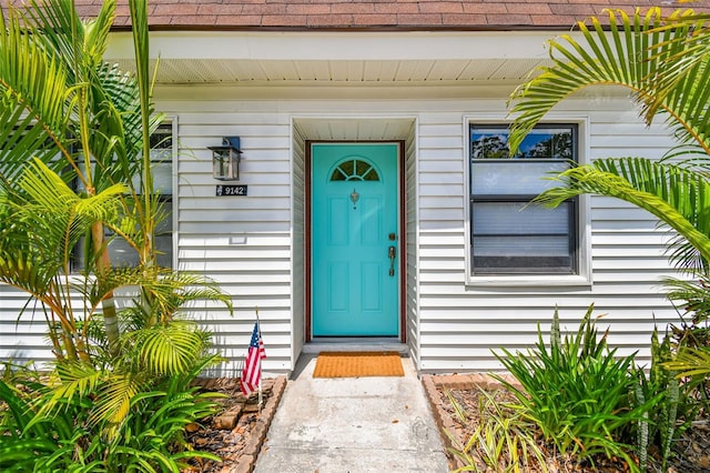 9142 Oakwood Ln, Seminole, FL 33776 - view of exterior entry featuring roof with shingles