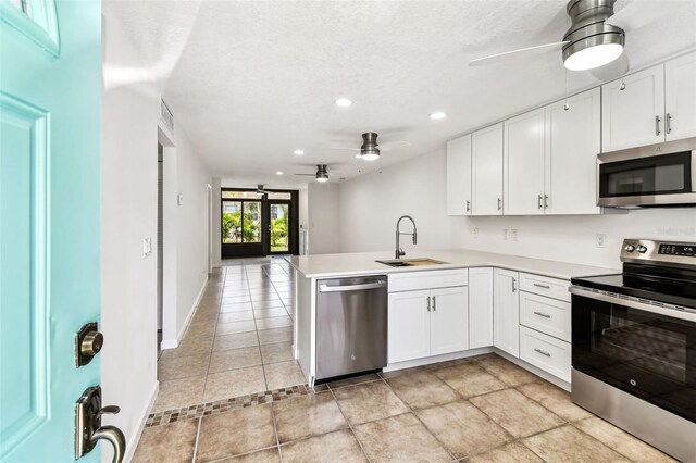9142 Oakwood Ln, Seminole, FL 33776 - kitchen with appliances with stainless steel finishes, ceiling fan, a sink, recessed lighting, and a peninsula