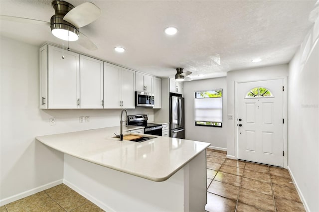 9142 Oakwood Ln, Seminole, FL 33776 - kitchen featuring appliances with stainless steel finishes, a sink, baseboards, light countertops, and recessed lighting