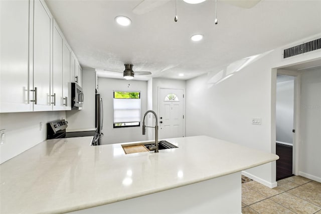 9142 Oakwood Ln, Seminole, FL 33776 - kitchen featuring appliances with stainless steel finishes, ceiling fan, a peninsula, a sink, and light countertops