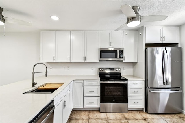 9142 Oakwood Ln, Seminole, FL 33776 - kitchen with stainless steel appliances, a ceiling fan, a sink, light countertops, and recessed lighting