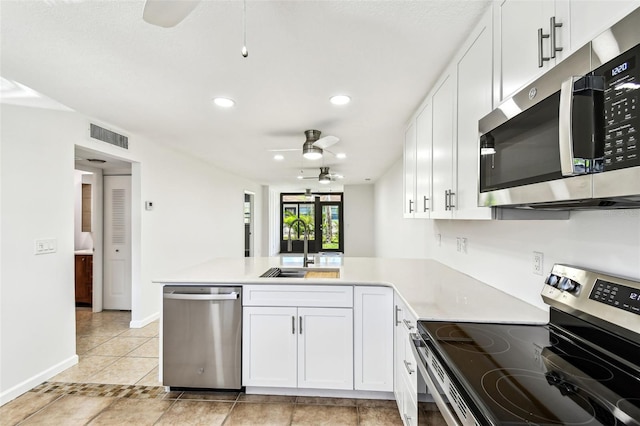 9142 Oakwood Ln, Seminole, FL 33776 - kitchen featuring appliances with stainless steel finishes, a ceiling fan, a peninsula, a sink, and light countertops