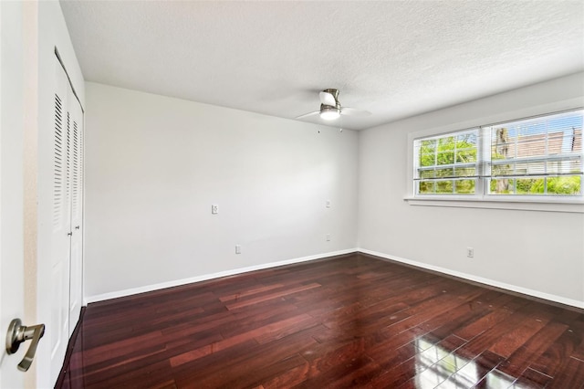 9142 Oakwood Ln, Seminole, FL 33776 - unfurnished bedroom with dark wood-type flooring, baseboards, a textured ceiling, a closet, and ceiling fan