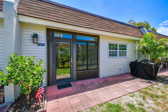 9142 Oakwood Ln, Seminole, FL 33776 - property entrance with roof with shingles and a patio
