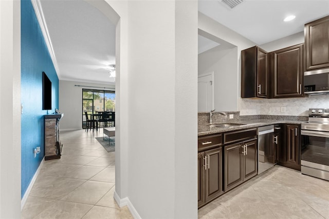 5153 Bay Isle Cir, Clearwater, FL 33760 - kitchen with appliances with stainless steel finishes, a sink, dark stone counters, dark brown cabinetry, and light tile patterned floors
