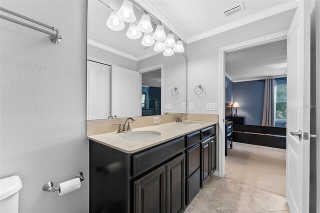 5153 Bay Isle Cir, Clearwater, FL 33760 - bathroom with double vanity, ornamental molding, connected bathroom, tile patterned floors, and toilet