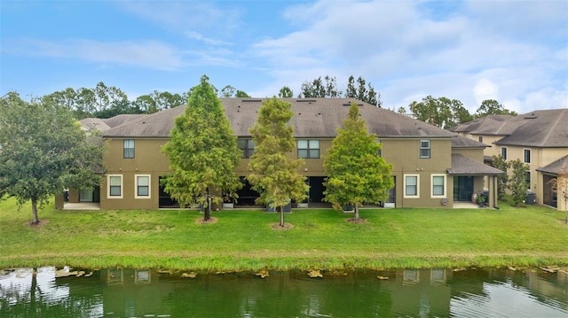 5153 Bay Isle Cir, Clearwater, FL 33760 - rear view of property with a water view, stucco siding, and a lawn