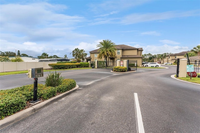 5153 Bay Isle Cir, Clearwater, FL 33760 - view of asphalt street with curbs, a gated entry, a gate, and a residential view