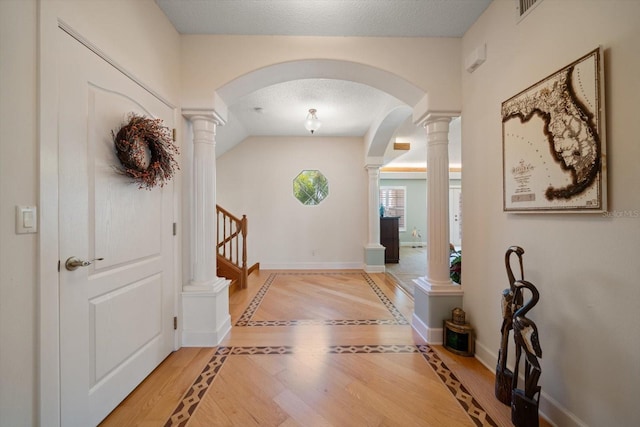3397 Bluefish Dr, Hernando Beach, FL 34607 - foyer with decorative columns, inlaid floor details, arched walkways, and a textured ceiling