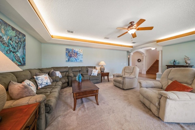 3397 Bluefish Dr, Hernando Beach, FL 34607 - living room with arched walkways, a ceiling fan, ornate columns, a textured ceiling, and light colored carpet