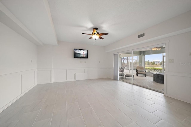 3397 Bluefish Dr, Hernando Beach, FL 34607 - empty room with a ceiling fan, a decorative wall, and a wainscoted wall