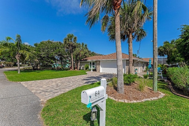 64 Alberta Ave, Ponce Inlet, FL 32127 - ranch-style house featuring an attached garage, decorative driveway, and a front lawn