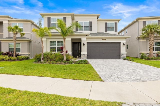 3541 Great Banyan Way, Wesley Chapel, FL 33543 - prairie-style house with stucco siding, a garage, decorative driveway, a front lawn, and stone siding