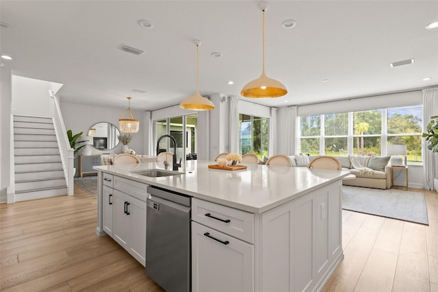 3541 Great Banyan Way, Wesley Chapel, FL 33543 - kitchen featuring stainless steel dishwasher, light wood-type flooring, healthy amount of natural light, an island with sink, and recessed lighting