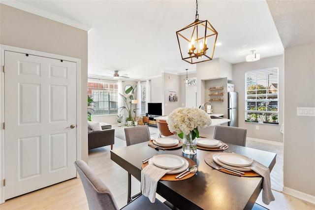 10412 White Lake Ct, Tampa, FL 33626 - dining room featuring a chandelier, light wood finished floors, baseboards, a ceiling fan, and crown molding