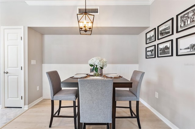 10412 White Lake Ct, Tampa, FL 33626 - dining area featuring a chandelier, crown molding, baseboards, and light wood-type flooring