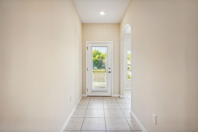 31215 Flannery Ct, Wesley Chapel, FL 33543 - doorway featuring arched walkways, light tile patterned floors, and baseboards
