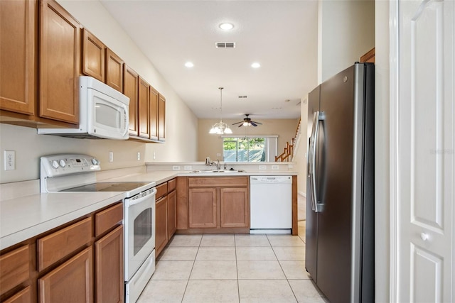 31215 Flannery Ct, Wesley Chapel, FL 33543 - kitchen featuring white appliances, a sink, light tile patterned flooring, brown cabinets, and light countertops