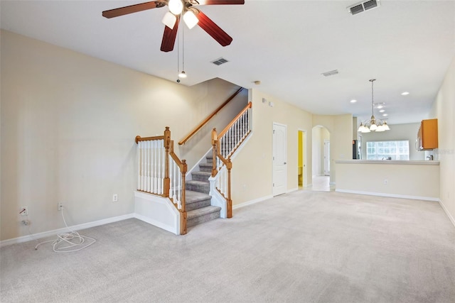 31215 Flannery Ct, Wesley Chapel, FL 33543 - unfurnished living room with light colored carpet, ceiling fan, arched walkways, stairs, and baseboards