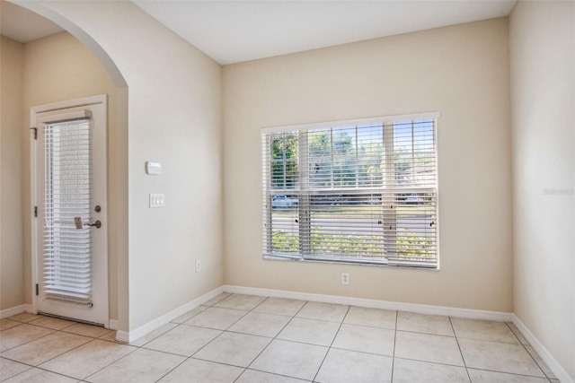 31215 Flannery Ct, Wesley Chapel, FL 33543 - spare room featuring arched walkways, plenty of natural light, and light tile patterned floors