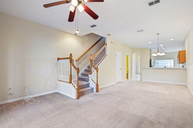 31215 Flannery Ct, Wesley Chapel, FL 33543 - unfurnished living room featuring light colored carpet, ceiling fan, arched walkways, stairway, and baseboards